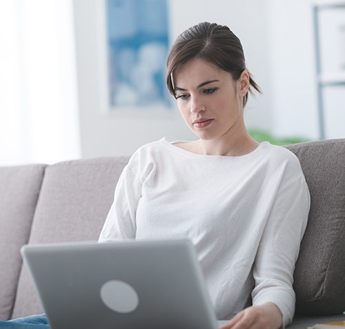 Cropped Woman Using A Laptop At Home